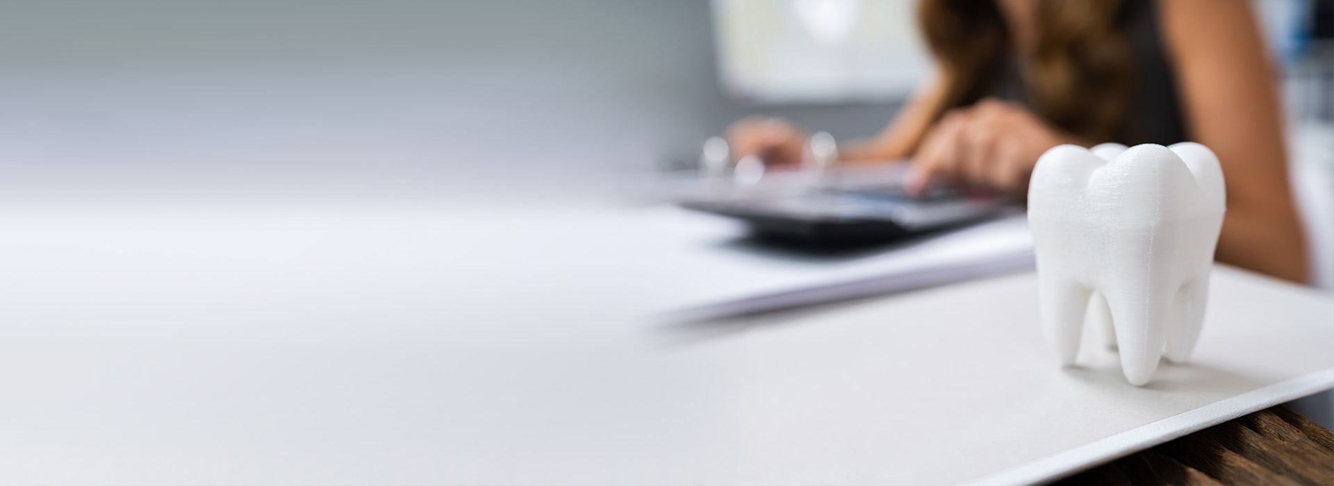 A person sitting at a desk with a laptop, accompanied by a close-up of a toothbrush.