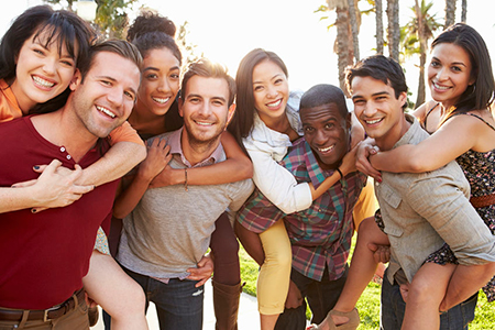 The image shows a group of people posing together with smiles on their faces for a photograph. They appear to be enjoying each other s company, possibly celebrating an occasion.